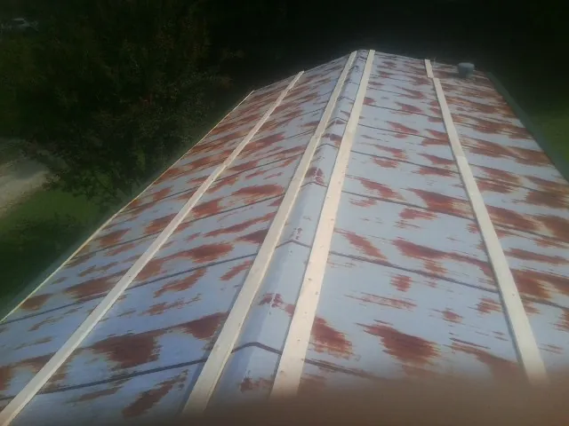 Rusted metal roof panels with new wood purlins before replacement — Storm Damage Roof Repair in Laura by Roofing Brothers